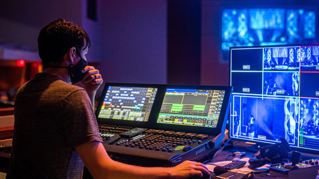 live event filming and live streaming service odense a man sitting inside a studio with tons of broadcast controllers and tv screens